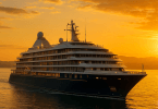 Abstract painting of a luxury cruise ship at sunset with a golden sky, illustrating opulence